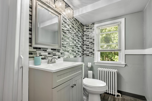 22 Hillside Ave, Torrington, CT 06790 - half bathroom with radiator heating unit, vanity, toilet, and tasteful backsplash