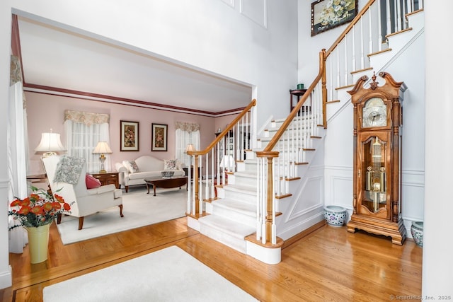 10 Deer Park Rd, Danbury, CT 06811 - foyer entrance with wood finished floors, stairs, a decorative wall, wainscoting, and a high ceiling