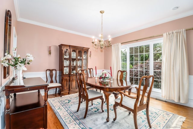 10 Deer Park Rd, Danbury, CT 06811 - dining room featuring a chandelier, a wainscoted wall, ornamental molding, and light wood-style floors