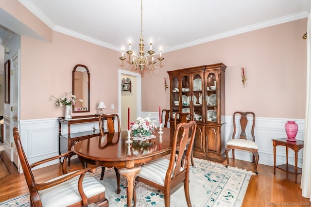 10 Deer Park Rd, Danbury, CT 06811 - dining room featuring a chandelier, ornamental molding, wood finished floors, and wainscoting