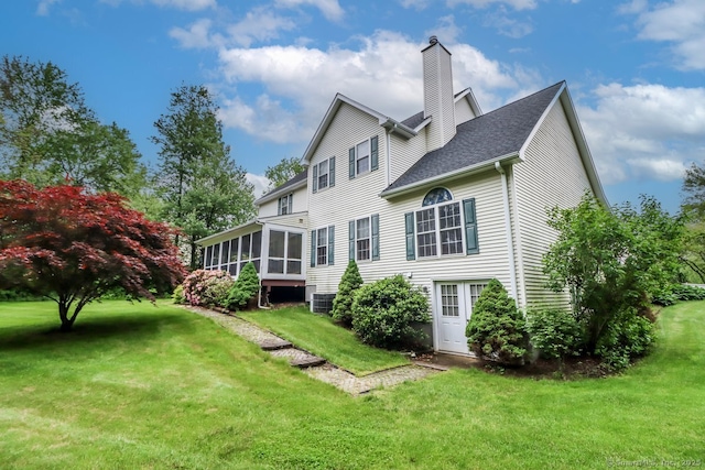 10 Deer Park Rd, Danbury, CT 06811 - back of property with a sunroom, a chimney, a yard, cooling unit, and roof with shingles