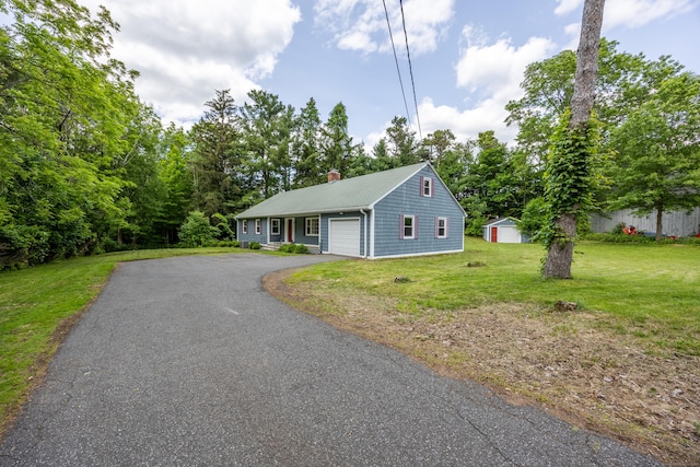 126 Newfield St, Middletown, CT 06457 - view of front of home featuring asphalt driveway, a chimney, a front lawn, an attached garage, and an outdoor structure
