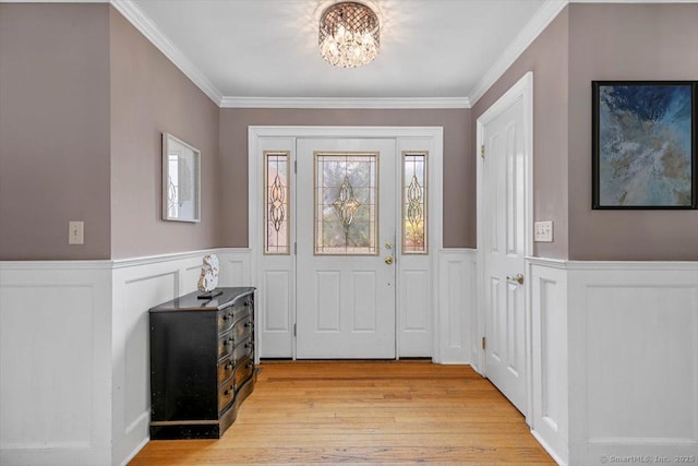 452 Burnt Plains Rd, Milford, CT 06461 - foyer with a chandelier, a wainscoted wall, light wood-style flooring, ornamental molding, and a decorative wall