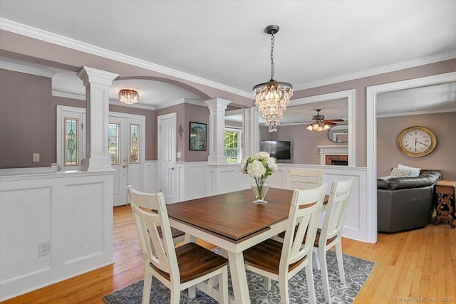 452 Burnt Plains Rd, Milford, CT 06461 - dining space with ornate columns, light wood-style flooring, healthy amount of natural light, wainscoting, and ornamental molding