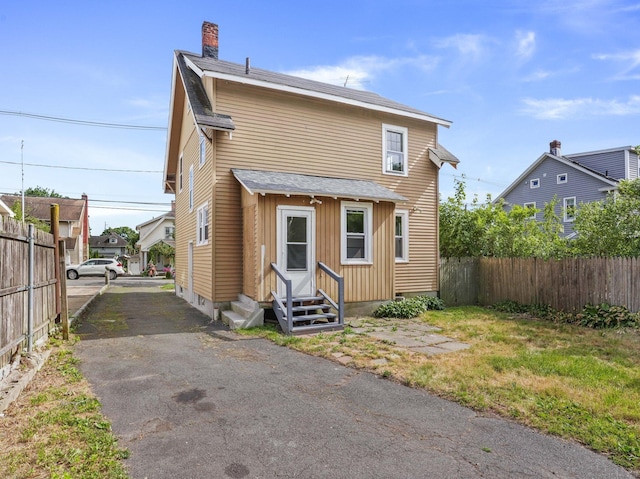 1 Raymond Ter, Norwalk, CT 06855 - back of house with entry steps, a chimney, and roof with shingles