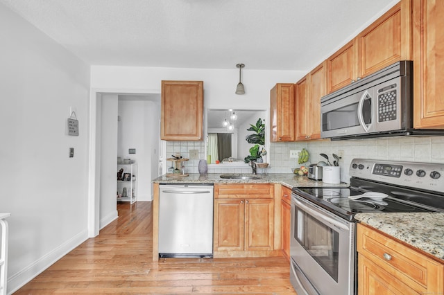 196 New Haven Ave Unit 322, Derby, CT 06418 - kitchen with appliances with stainless steel finishes, light wood-style floors, tasteful backsplash, a sink, and light stone countertops