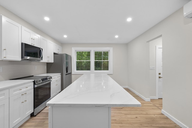123 Lower Rd, North Canaan, CT 06024 - kitchen with appliances with stainless steel finishes, a center island, decorative backsplash, white cabinetry, and light wood finished floors