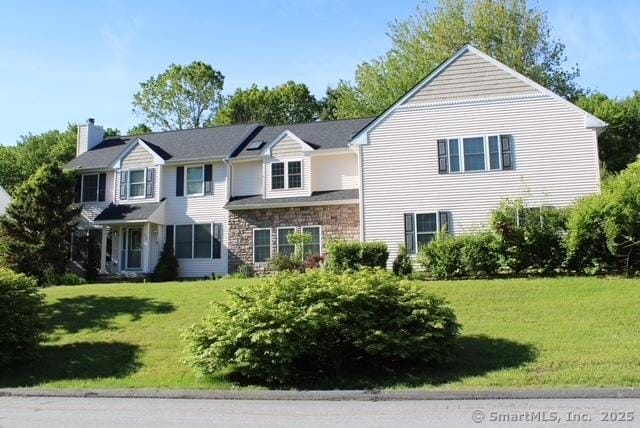 236 Ginger Ln, Torrington, CT 06790 - view of front of home featuring a front yard, stone siding, and a chimney