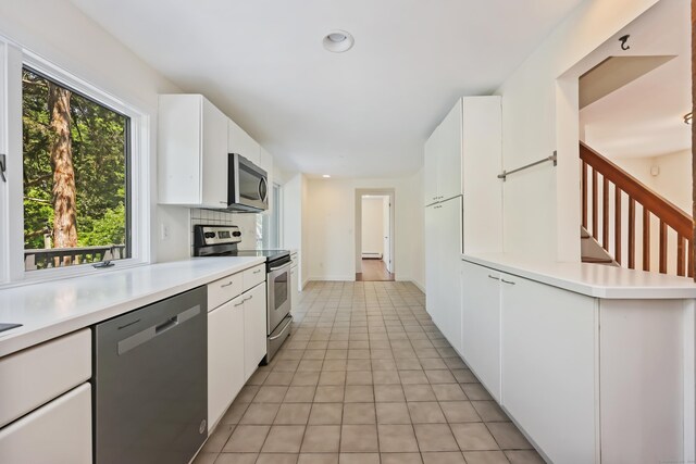 15 Grumman Ave, Norwalk, CT 06851 - kitchen featuring stainless steel appliances, light countertops, white cabinetry, light tile patterned flooring, and recessed lighting