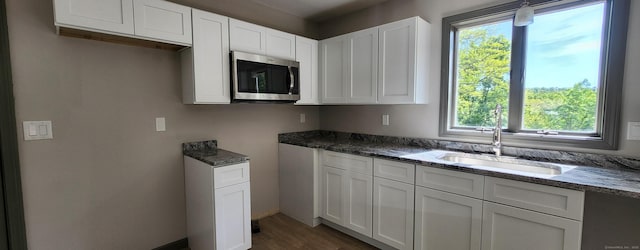 552 Squaw Rock Rd, Plainfield, CT 06354 - kitchen with stainless steel microwave, dark stone countertops, a sink, and white cabinets