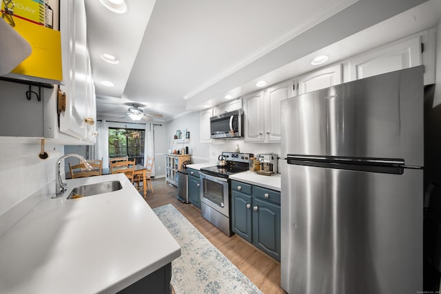 50 Aiken St Apt 463, Norwalk, CT 06851 - kitchen featuring stainless steel appliances, a sink, blue cabinets, recessed lighting, and light countertops