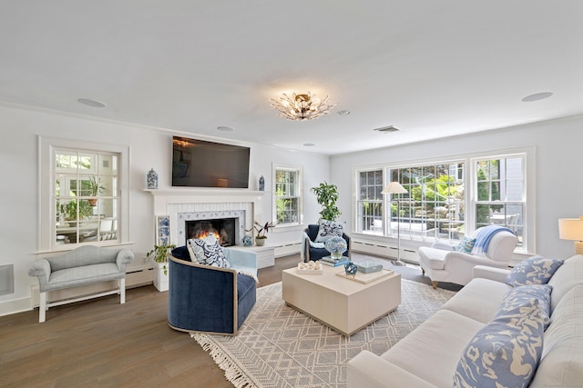 15 Mill Rd, New Canaan, CT 06840 - living area with a warm lit fireplace, wood finished floors, baseboard heating, and ornamental molding