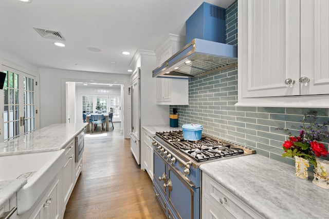15 Mill Rd, New Canaan, CT 06840 - kitchen featuring wall chimney range hood, stainless steel microwave, range, white cabinetry, and healthy amount of natural light
