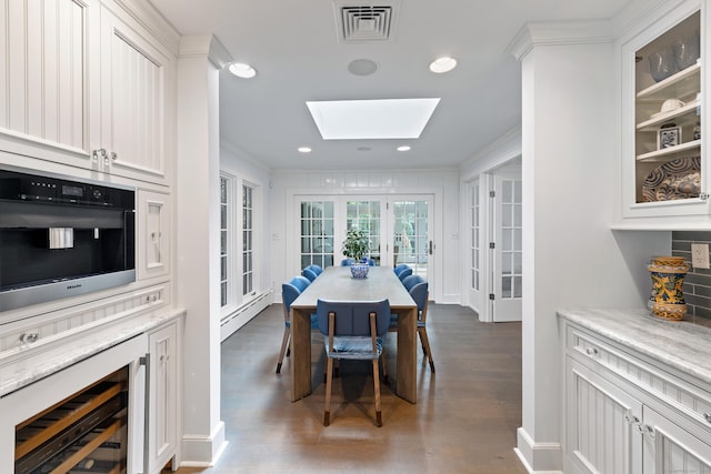 15 Mill Rd, New Canaan, CT 06840 - dining space with wine cooler, baseboard heating, wood finished floors, french doors, and a skylight