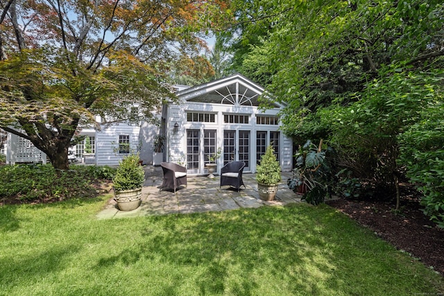 15 Mill Rd, New Canaan, CT 06840 - back of property featuring french doors, a lawn, and a patio