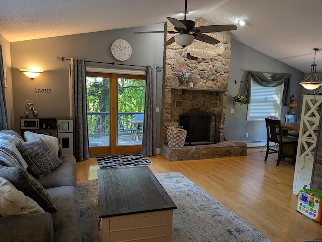 51 Isleib Rd, Marlborough, CT 06447 - living area featuring vaulted ceiling, ceiling fan, wood finished floors, a fireplace, and a baseboard heating unit