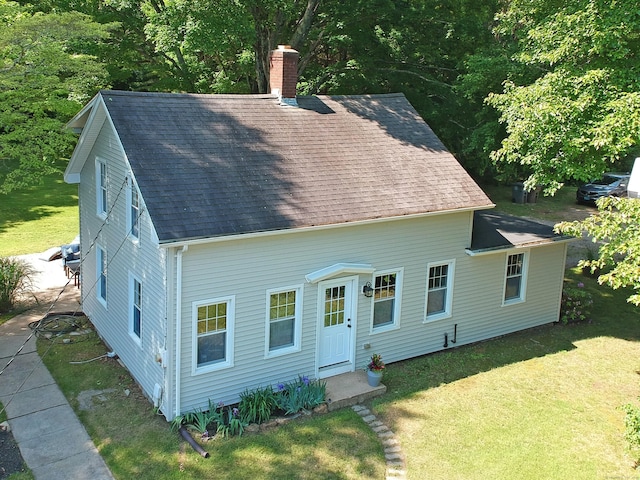 276 Boston Post Rd, East Lyme, CT 06333 - rear view of property featuring a shingled roof, a chimney, and a lawn