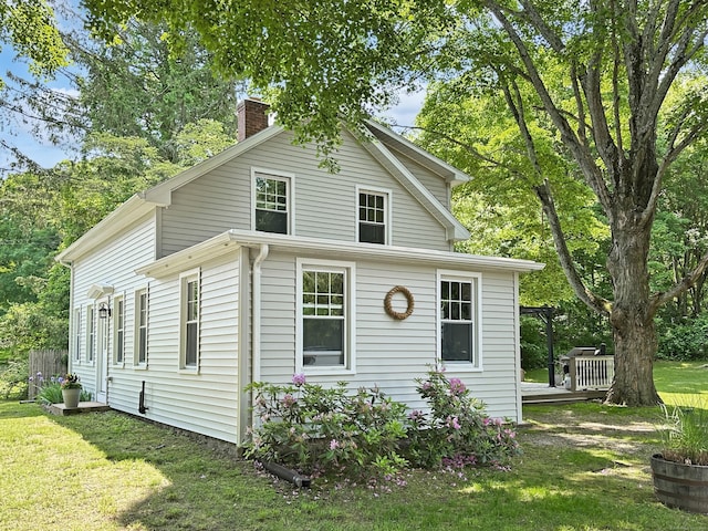 276 Boston Post Rd, East Lyme, CT 06333 - view of front facade featuring a chimney, a deck, and a front yard