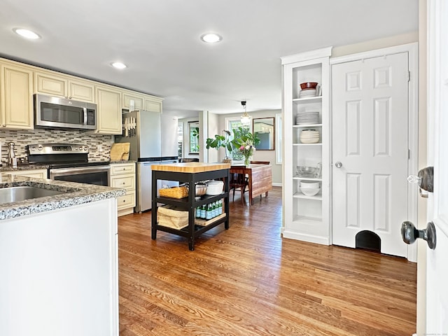276 Boston Post Rd, East Lyme, CT 06333 - kitchen with appliances with stainless steel finishes, cream cabinets, light wood-type flooring, tasteful backsplash, and recessed lighting