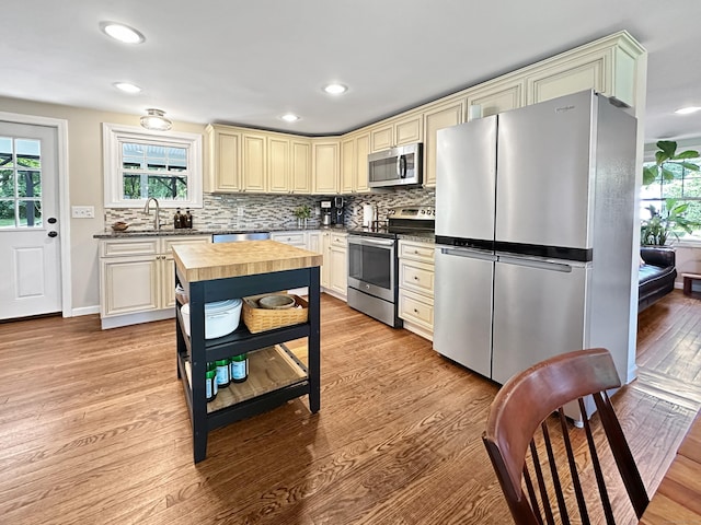 276 Boston Post Rd, East Lyme, CT 06333 - kitchen featuring appliances with stainless steel finishes, cream cabinets, wooden counters, a sink, and light wood-style floors