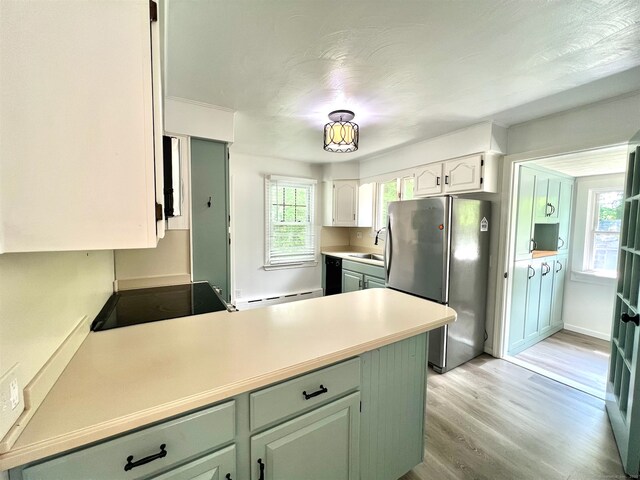 55 Lancaster St, Watertown, CT 06779 - kitchen featuring freestanding refrigerator, a baseboard heating unit, a peninsula, light wood-type flooring, and a sink