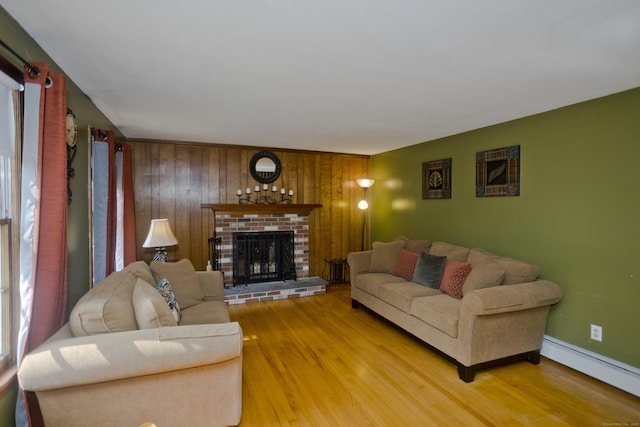 42 Sycamore Ter, Windham, CT 06280 - living room featuring a baseboard heating unit, light wood finished floors, a fireplace, and wooden walls