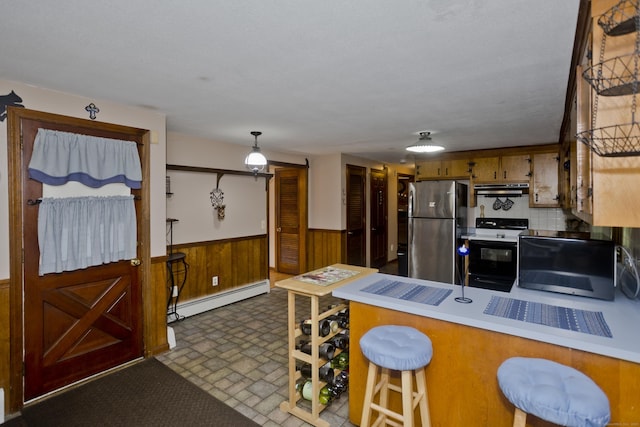 42 Sycamore Ter, Windham, CT 06280 - kitchen with baseboard heating, electric range, freestanding refrigerator, under cabinet range hood, and a peninsula