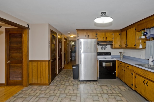 42 Sycamore Ter, Windham, CT 06280 - kitchen featuring electric range oven, freestanding refrigerator, light countertops, brown cabinets, and a wainscoted wall