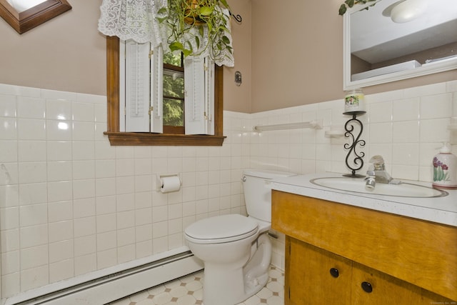 42 Sycamore Ter, Windham, CT 06280 - half bath with a baseboard heating unit, vanity, tile walls, wainscoting, and tile patterned floors