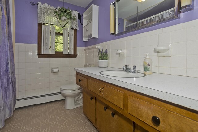 42 Sycamore Ter, Windham, CT 06280 - bathroom featuring baseboard heating, vanity, tile walls, wainscoting, and curtained shower