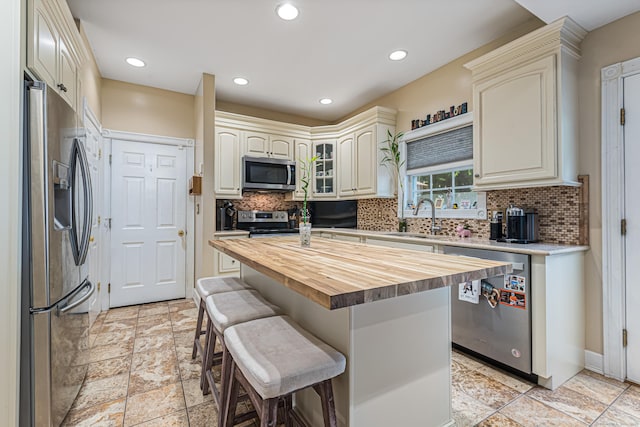 59 Woodbine Rd, Colchester, CT 06415 - kitchen with stainless steel appliances, butcher block countertops, a sink, a kitchen bar, and backsplash