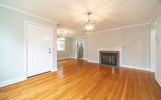 43 Breyer Ave, Bridgeport, CT 06606 - unfurnished living room featuring a chandelier, light wood-style flooring, a brick fireplace, baseboards, and crown molding