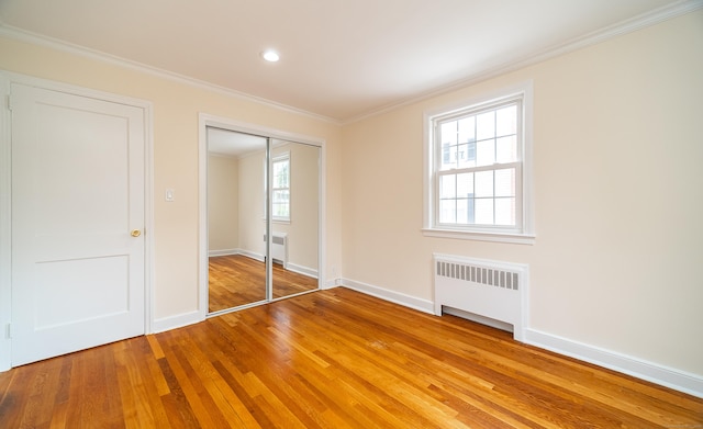 43 Breyer Ave, Bridgeport, CT 06606 - unfurnished bedroom with radiator, light wood-style floors, ornamental molding, baseboards, and a closet