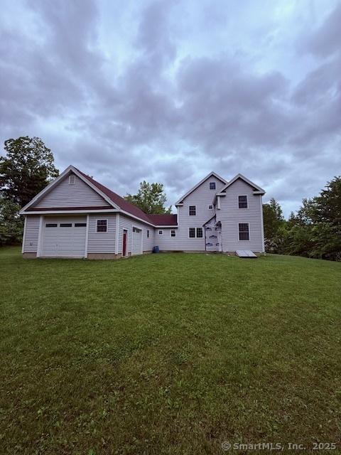 15 Suffield St, Windsor Locks, CT 06096 - rear view of house with a lawn and a garage