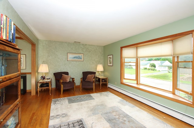 43 Redwood Cir, Shelton, CT 06484 - living area featuring a baseboard heating unit, wood finished floors, and an accent wall