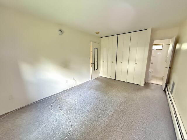 14 Arrowhead Way Apt C6, Woodbury, CT 06798 - unfurnished bedroom with baseboard heating, carpet flooring, connected bathroom, and a closet