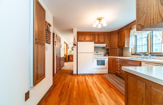 258 New Cheshire Rd, Wallingford, CT 06492 - kitchen with white appliances, under cabinet range hood, brown cabinetry, light wood-style floors, and light countertops