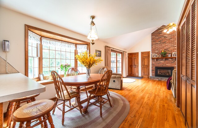 258 New Cheshire Rd, Wallingford, CT 06492 - dining space featuring a fireplace, light wood-style floors, and vaulted ceiling