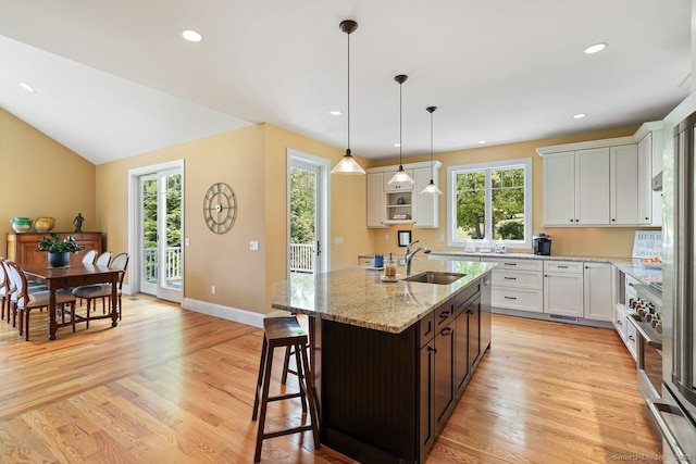 8 Meadowview Dr, Brookfield, CT 06804 - kitchen featuring an island with sink, light stone counters, white cabinetry, light wood finished floors, and recessed lighting