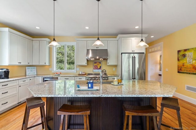 8 Meadowview Dr, Brookfield, CT 06804 - kitchen featuring freestanding refrigerator, under cabinet range hood, light wood-type flooring, a kitchen bar, and recessed lighting