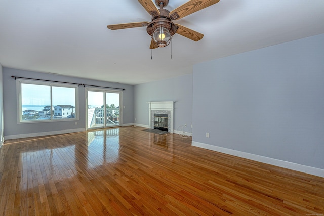 2 Mansfield Grove Rd Apt 374, East Haven, CT 06512 - unfurnished living room featuring wood-type flooring, a fireplace with flush hearth, a ceiling fan, and baseboards