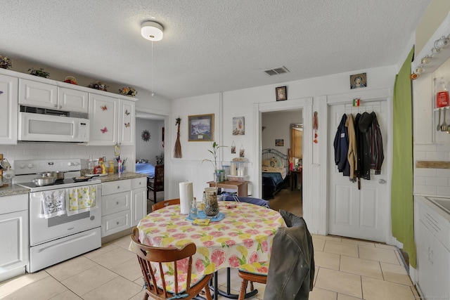 127 Smalley St, New Britain, CT 06051 - kitchen with white appliances, light tile patterned flooring, light countertops, a textured ceiling, and backsplash