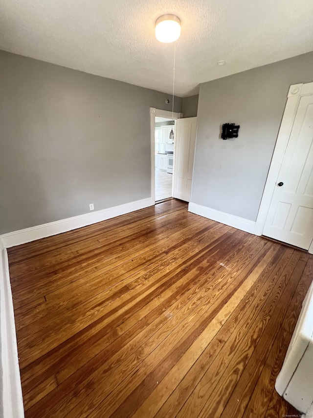 127 Smalley St, New Britain, CT 06051 - spare room featuring wood finished floors, baseboards, and a textured ceiling