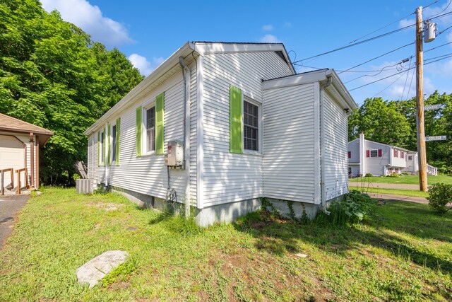 134 Mansfield Grove Rd, East Haven, CT 06512 - view of side of home featuring a yard, cooling unit, and a garage