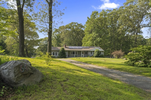 64 Obed Hts, Old Saybrook, CT 06475 - ranch-style home with roof mounted solar panels, a front lawn, a chimney, and dirt driveway