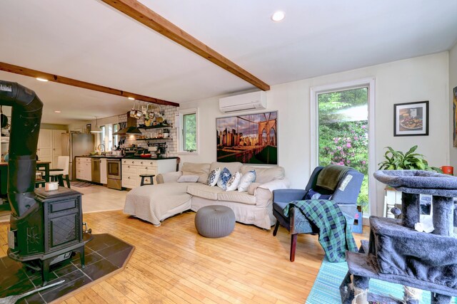 225 Rocky Mountain Rd, Southbury, CT 06488 - living area featuring a wall mounted AC, beam ceiling, healthy amount of natural light, a wood stove, and hardwood / wood-style flooring