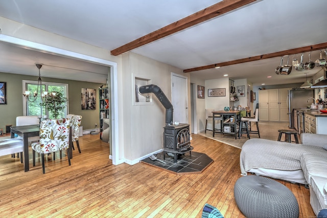 225 Rocky Mountain Rd, Southbury, CT 06488 - living area featuring a wood stove, light wood-style floors, beam ceiling, a chandelier, and baseboards