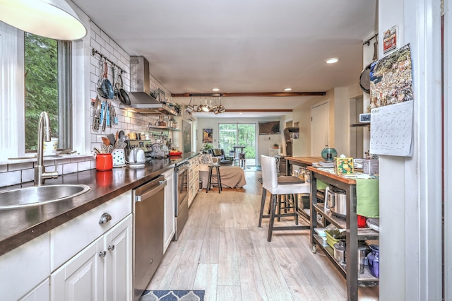 225 Rocky Mountain Rd, Southbury, CT 06488 - kitchen with stainless steel dishwasher, dark countertops, a sink, wall chimney exhaust hood, and light wood-style floors