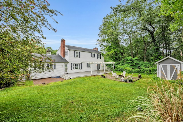 206 Ludlow Rd, Manchester, CT 06040 - back of house with a storage unit, a chimney, a lawn, and a patio area