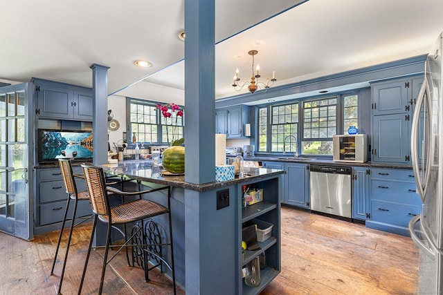 27 Tobey Hill Rd, North Canaan, CT 06018 - kitchen with stainless steel appliances, open shelves, blue cabinetry, a breakfast bar, and light wood-style flooring